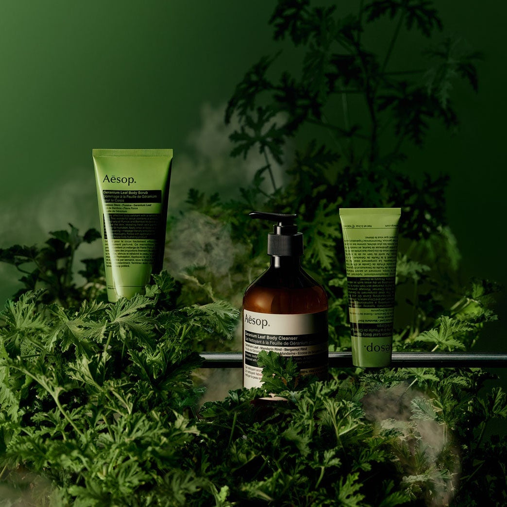 Cosmetic products on a green background with plants